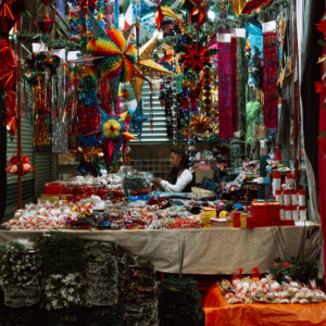 Colorful Christmas decorations at a market stall in Mexico City, CDMX, with festive lights and ornaments.